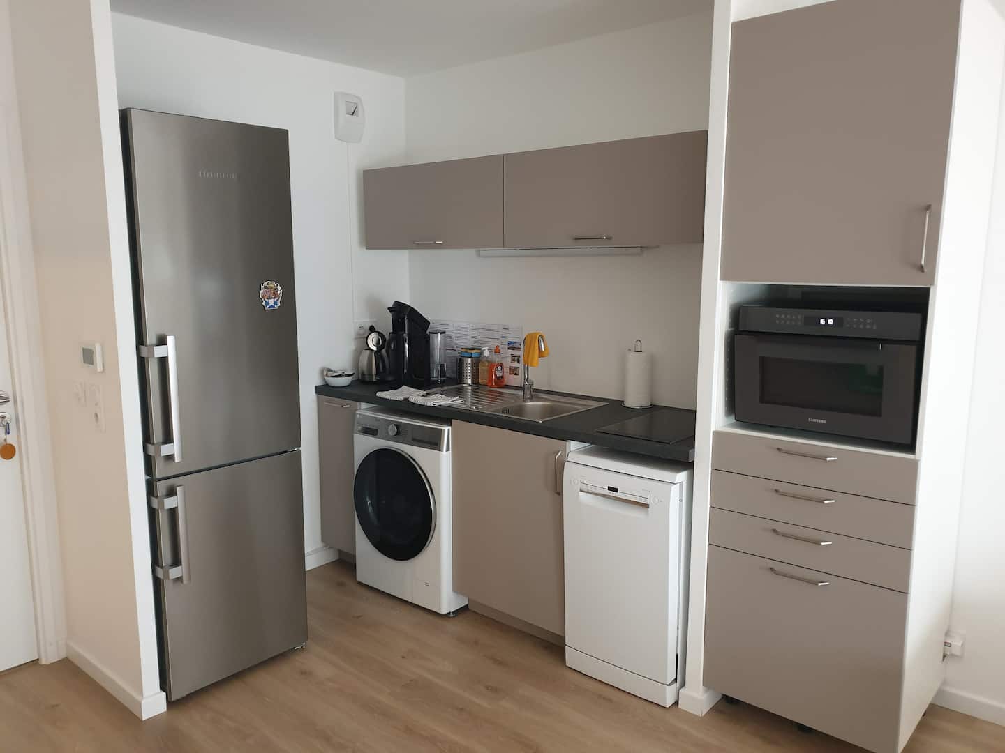 La cuisine partagée commune aux 3 chambres. Toute équipée, frigo, congélateur, lave linge/sèche linge, lave vaisselle, four/micro-onde et tout le nécessaire vaisselle.